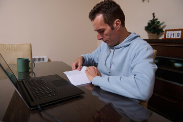 Home Office Day: Father Working Remotely On Paperwork At Laptop