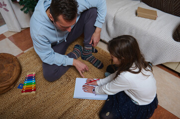 Obraz premium Father And Daughter Draw Together At Home For A Cozy Family Moment