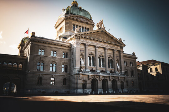 Neoclassical government building with a dramatic cupola in Bern, Switzerland. High-contrast image focusing on European architecture, history, and monumental design.