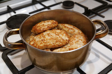 Meat cutlets are stewed in saucepan after being fried in a frying pan