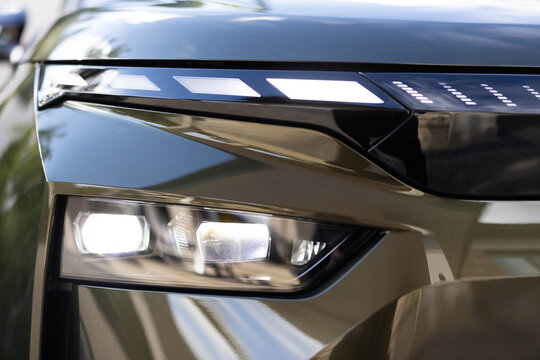 Switched on led matrix lights of luxury car. Car front full led matrix IQ Light. Modern car headlamp flashing light with blinking on continuously indicator. Car Blinker Light.