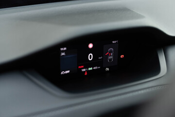 Electric car digital display panel. Close up shot of hybrid car instrument panel. Fully electric car dashboard trip computer display showing the status of the battery and available range in kilometers