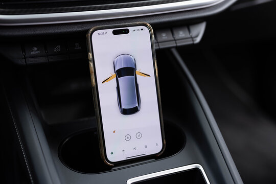 Smart phone with application for electric vehicles. controlling electric car charging level via mobile app. Car status information on the mobile app. Concept of modern and smart technologies - Powered by Adobe