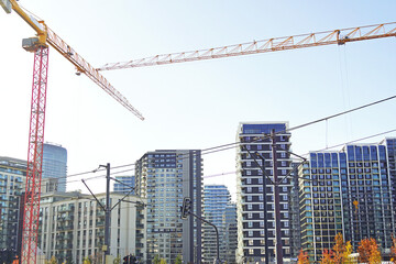 Landscape with tower cranes, traffic lights, power lines and the modern residential complex Belgrade Waterfront. Symbolizes vertical city growth, high-rise development, and construction boom.