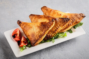 Vendorstyle crispy fried pastry triangles accompanied by salad and rich
