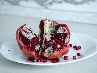 pomegranate on a plate on a white table. pomegranate cutting