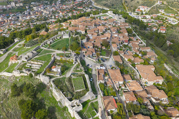 Aerial view of Berat Castle highlighting its stone ruins, traditional hilltop homes and historic streets overlooking the city.