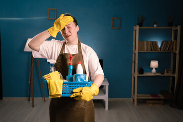 Cleaning service concept. Confused sad woman cleaner in apron with detergents showing epic fail...