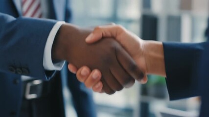 Close-up shot of a firm handshake between two diverse business professionals sealing a deal in a modern office, symbolizing partnership and agreement - Powered by Adobe