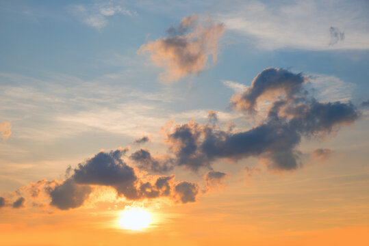 sinking sun and yellow shine, blue sky with some grey clouds above