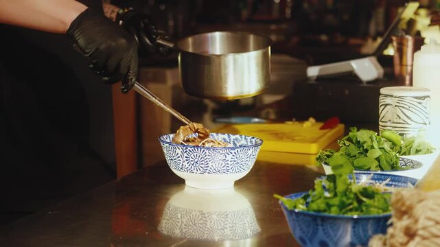 Chef Adding Beef Slices to Traditional Vietnamese Pho Bo Soup