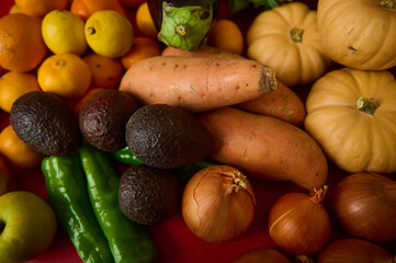 Colorful Autumn Produce Display With Sweet Potatoes Avocados Pumpkins Onions And Peppers