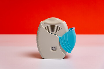 Asthma inhaler for asthma and COPD patients. Bronchodilator medicine with salbutamol for patients with asthma, allergy and Chronic Obstructive Pulmonary Diseaseon on orange background.