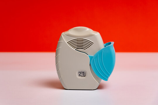 Asthma inhaler for asthma and COPD patients. Bronchodilator medicine with salbutamol for patients with asthma, allergy and Chronic Obstructive Pulmonary Diseaseon on orange background.