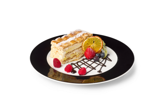 Decorative mille-feuille pastry serving on a plate with fresh berries and orange slice
