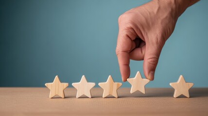 Star rating hand: A hand carefully places a star, completing a row of wooden stars, a visual representation of quality, excellence and customer satisfaction. 