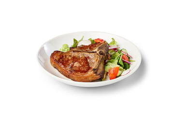 Plated grilled T bone beef steak and mixed greens on a white background