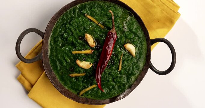 Makki Ki Roti & Sarson Ka Sag is basically Corn floor flat bread & curry using mustard greens respectively. Popular Punjabi food. Served in a bowl and plate over moody background. selective focus