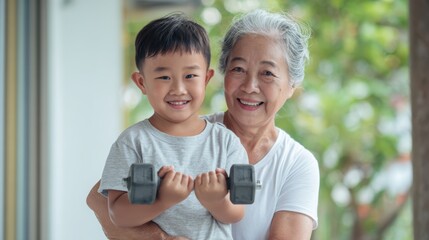 Happy Asian grandmother helps her young grandson lift a dumbbell, smiling during an outdoor fitness session. Promoting healthy lifestyle, family support, and active aging.