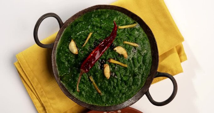 Makki Ki Roti & Sarson Ka Sag is basically Corn floor flat bread & curry using mustard greens respectively. Popular Punjabi food. Served in a bowl and plate over moody background. selective focus