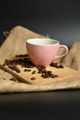 High-quality photo of a gourmet coffee break setup. The scattered beans and rustic textures of wood and burlap enhance the feeling of warmth and tranquility for a perfect start to the day.