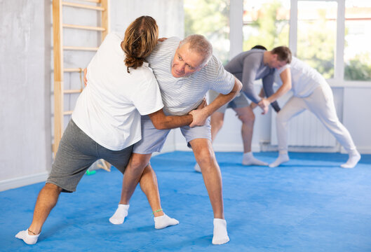 Elderly man learns to do a painful hold in self-defense classes