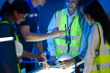 A happy logistics team reviews a successful plan. The diverse group discusses an AI strategy for smart factory optimization, efficiency, and sustainable (ESG) goals.