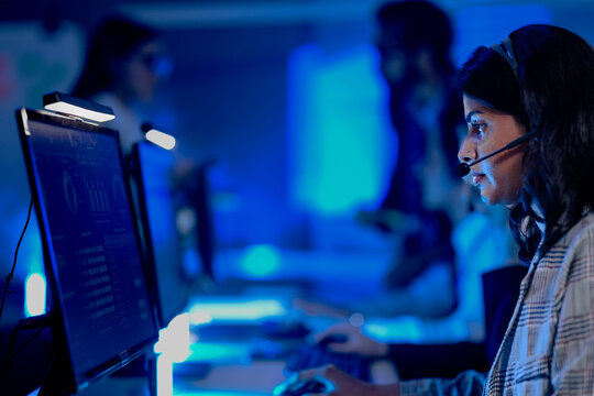 Data integrity check night shift Diverse team meticulously audits financial performance comparing figures tablet screen printed reports ensuring accuracy crucial validation process underway hub.