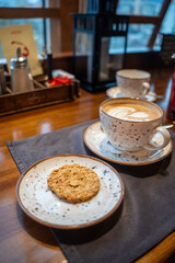 Coffee and cookie on cafe table. Cozy break time.