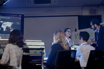 Future mission control synergy Diverse team leverages AI predictive insights interactive screens guide complex operations leader directs augmented human AI team achieve optimal results faster.