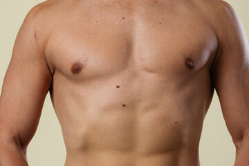Fototapeta premium A close-up of a slender young man's torso. Male body parts: defined abs and toned chest. Scene: a doctor's appointment in an X-ray room. moles and birthmarks on the body