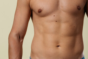 Fototapeta premium A close-up of a slender young man's torso. Male body parts: defined abs and toned chest. Scene: a doctor's appointment in an X-ray room. moles and birthmarks on the body