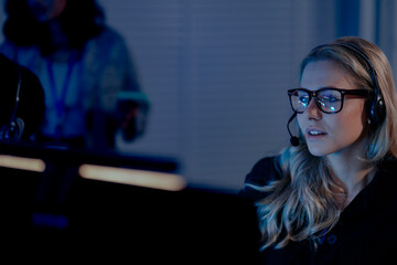 Command center lead focused intense monitoring critical systems late night headset connects team analyzing real time data screen crucial vigilance protects infrastructure operation underway now execut