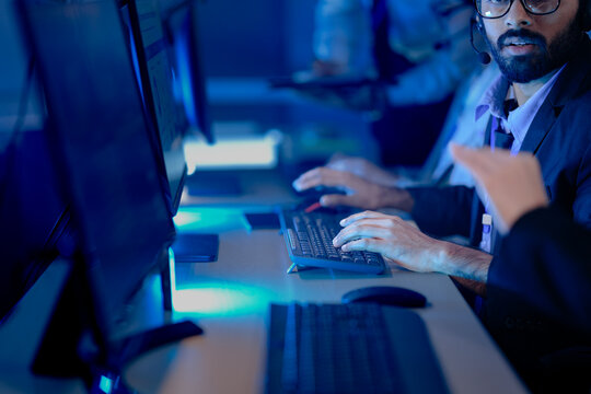 Night watch cybersecurity team collaborates intensely. Diverse male and female analysts monitor multiple screens, tracking active threats, protecting critical infrastructure vital digital. - Powered by Adobe