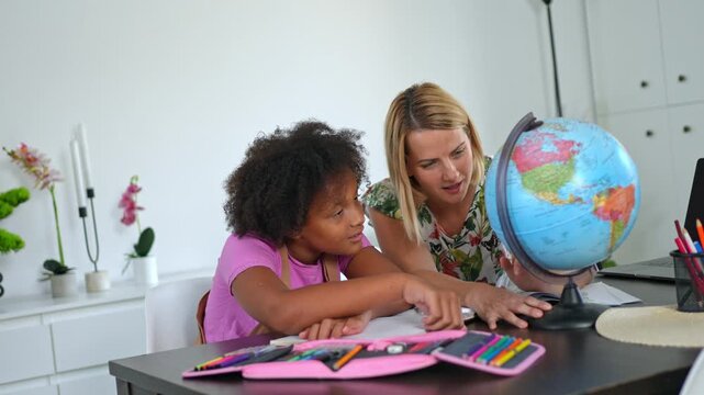 Mother teaching her daughter geography at home