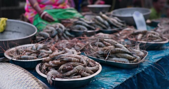 Fish market vendor cutting fresh fish for customers in a busy seafood market