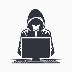 Shadowy hooded figure intently uses a computer keyboard in front of an obscured monitor
