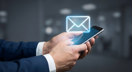 Businessman holding a smartphone with an email icon glowing above