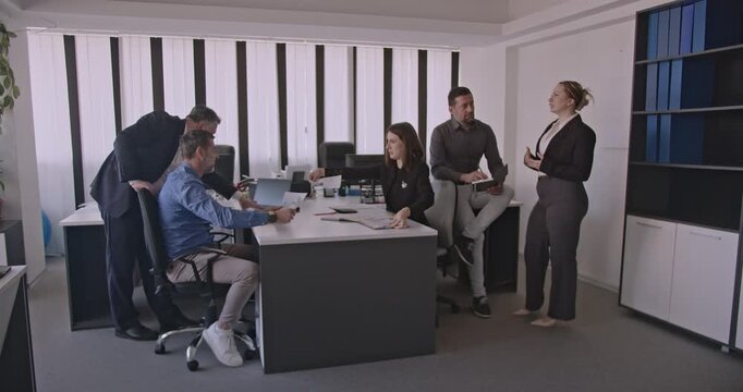 Business colleagues discuss ideas and strategies during a productive meeting in a modern office. - Powered by Adobe