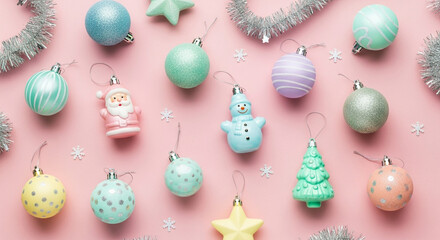 Flat lay of pastel colored christmas ornaments on a pink background