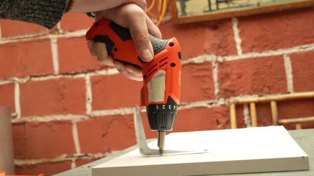 Close-up of Handyman Fastening Wood Panel with Cordless Drill