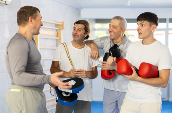 Athletic men talking to each other after boxing training in the gym