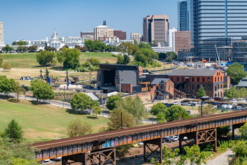 Naklejka premium Wide landscape photograph capturing the contrast between Richmond's modern glass skyscrapers and the natural beauty of the James River Park System.