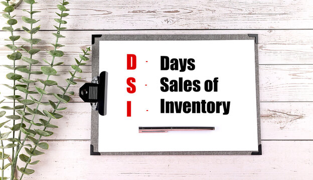 DSI abbreviation for days sales of inventory written on clipboard with pen and green plant on white wooden background - Powered by Adobe