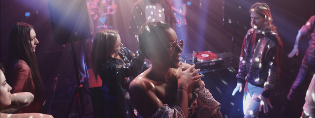 Nightlife party scene with vibrant lights and lively dancers enjoying music at a trendy club