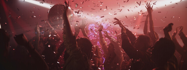 Exciting party atmosphere in a club with colorful lights and people celebrating joyfully at night