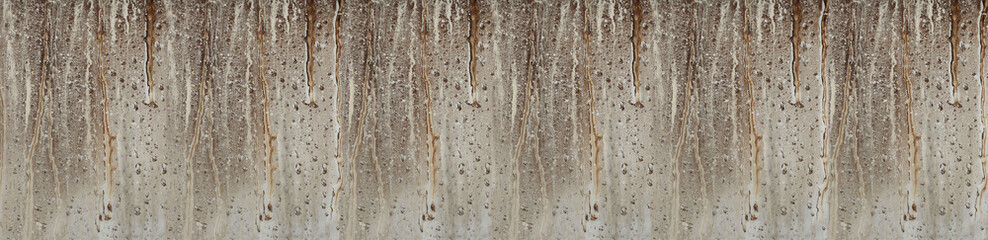 Obraz premium Weathered concrete wall with brown rust stains and dripping patterns creating natural vertical texture background