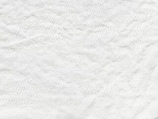 Fototapeta premium close-up view of wrinkled white fabric texture on a light blue background featuring subtle waves and creases