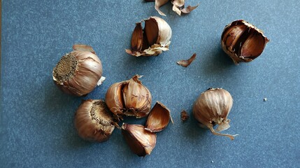 Obraz premium Peeled black garlic cloves on blue surface