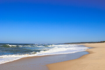 Long sandy beach with strong waves under clear blue sky Portugal, Ovar – Furadouro, 10.10.2025